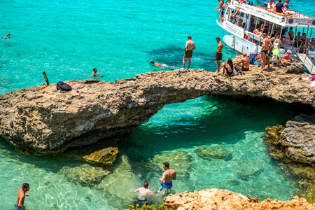 Comino, Malta - July 23, 2019. Tourists crowd at Blue Lagoon to enjoy the clear turquoise water on a sunny summer day with boats on Comino island, Malta.のeditorial素材