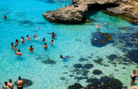 Comino, Malta - July 23, 2019. Tourists crowd at Blue Lagoon to enjoy the clear turquoise water on a...