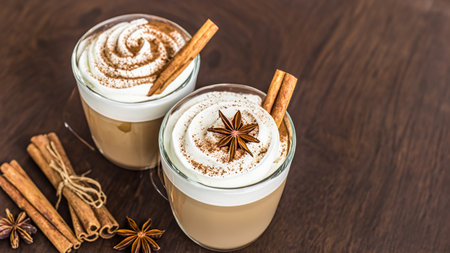 caffe latte with whipped cream, cinnamon and anise in a glassの素材