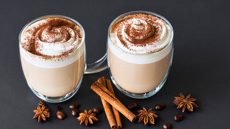 caffe latte with whipped cream, cinnamon and anise in a glassの素材