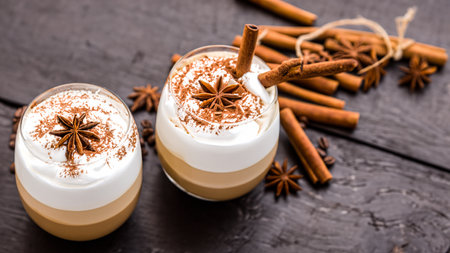 caffe latte with whipped cream, cinnamon and anise in a glassの素材
