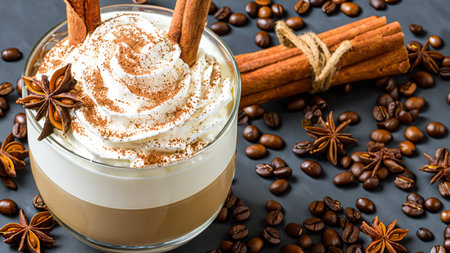 caffe latte with whipped cream, cinnamon and anise in a glassの素材