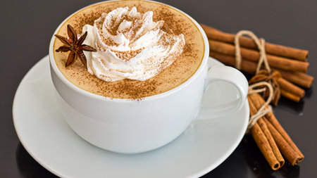 caffe latte with whipped cream, cinnamon and anise in a glassの素材