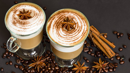 caffe latte with whipped cream, cinnamon and anise in a glassの素材