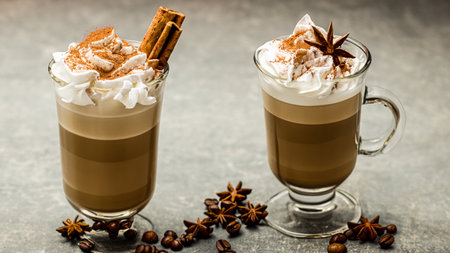 caffe latte with whipped cream, cinnamon and anise in a glassの素材