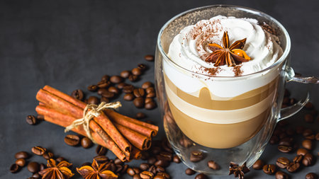 caffe latte with whipped cream, cinnamon and anise in a glassの素材