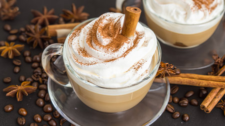 caffe latte with whipped cream, cinnamon and anise in a glassの素材