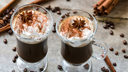 caffe latte with whipped cream, cinnamon and anise in a glassの素材