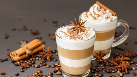 caffe latte with whipped cream, cinnamon and anise in a glassの素材