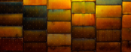 a wall made by rusty metal plates with gold dotsの写真素材