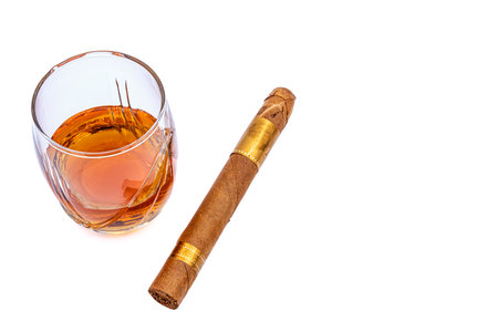 glass of cognac and cigar on white backgroundの写真素材