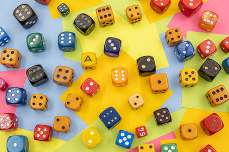colourful dices on a table with multicolored paper sticky notes on backgroundの写真素材