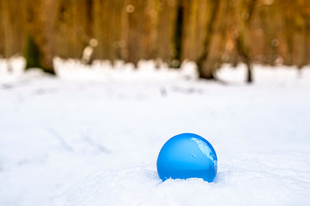 crystal earth globe on snow, selective focusの写真素材