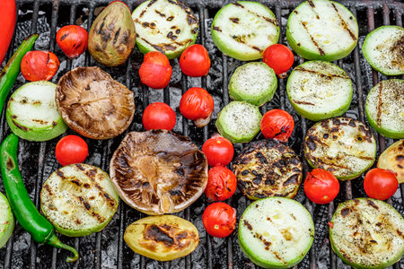 Grilled vegetables hot peppersi, zucchini slices, potatoes, eggplant slices, cherry tomatoes, mushrooms on bbq grill rack over charcoalの写真素材
