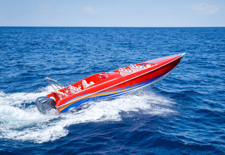 Red speed powerboat on blue waterの写真素材