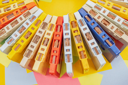 Top view of a collection of old vintage retro multicolored audio tape cassettes with a background of multicolored paper sticky notesの写真素材