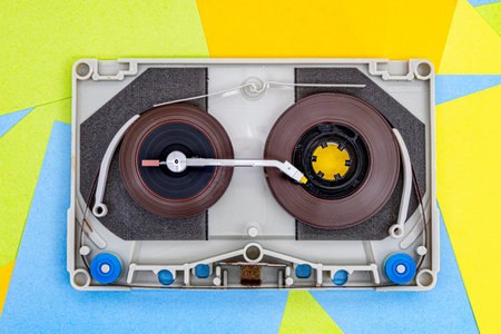 Top view of old vintage retro audio tape cassettes with a turntable arm on a background of multicolored paper sticky notesの写真素材