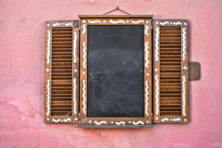 window wooden shutters with chalk board on the wallの写真素材