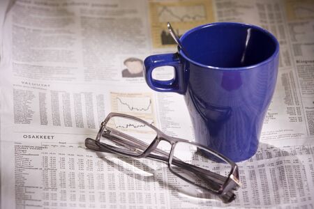 Cup of coffee and Sunday morning edition newspaper with glassesの写真素材