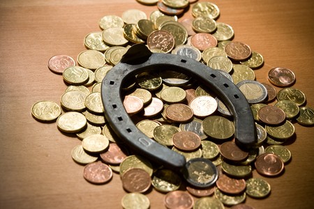 Old lucky horseshoe with euro coins