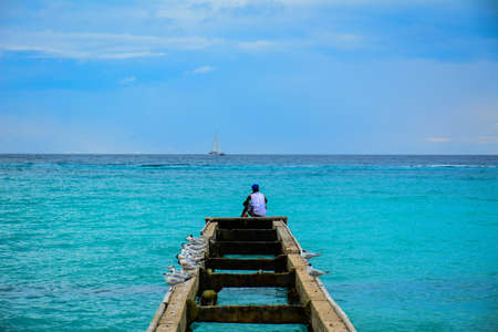 Man watching a boat at the horizonの写真素材