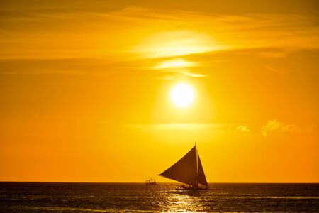 Sunset in Boracay, Philippines with a boat in the foregroundの写真素材