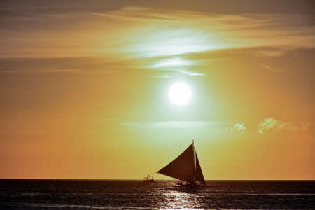 Sunset in Boracay, Philippines with a boat in the foregroundの写真素材