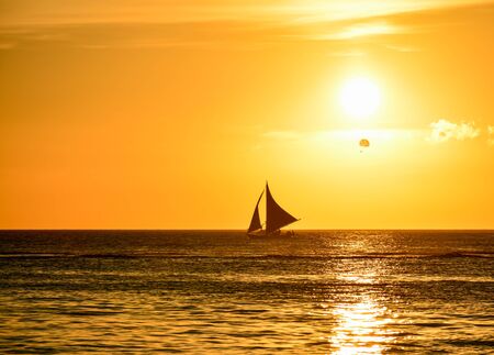 Sunset in Boracay, Philippines with a boat in foregroundの写真素材