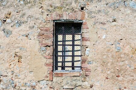 Window carved in stone in a building near a church in Tuscanyの写真素材