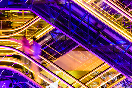 Colorful escalators  lit by neons with silhouette of two personの写真素材
