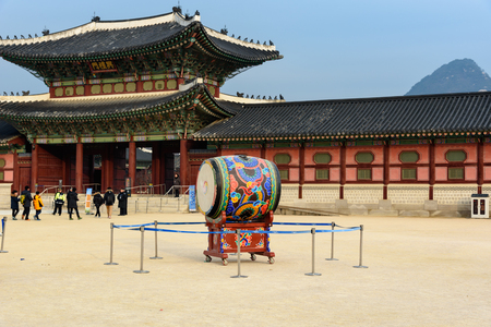 SEOUL, SOUTH KOREA - DECEMBER 31, 2016 - The drum inside the main square of Gyeongbokgung Palace in Seoul while a group of tourists comes to visit the palace.のeditorial素材