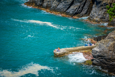 MANAROLA, ITALY - APRIL 29, 2017 - People relaxing on the cliffs near the town of Manarola.のeditorial素材
