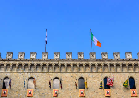 SIENA, ITALY - JULY 2, 2017 - The flags participating in the Palio di Siena exhibited in the palace of Rocca Salimbeni headquarters of the bank Monte dei Paschi di Siena.の写真素材
