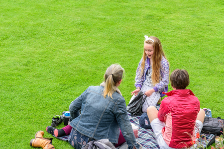 STIRLING, UNITED KINGDOM - AUGUST 9, 2017 - A family makes a picnic in a green meadow inside Stirling Castle in Scotland in summerの写真素材