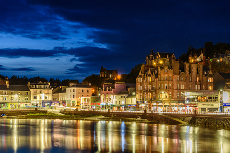 OBAN, SCOTLAND - AUGUST 14, 2017 - Night view of the bay of the beautiful town of Oban with lights reflection.のeditorial素材