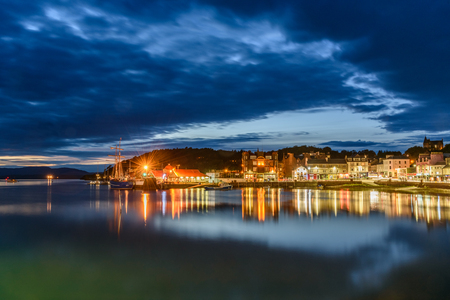 OBAN, SCOTLAND - AUGUST 14, 2017 - Night view of the bay of the beautiful town of Oban with lights reflection.のeditorial素材