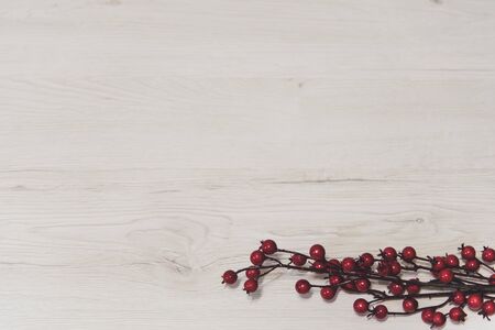 A branch of red berries on a wooden background.の写真素材