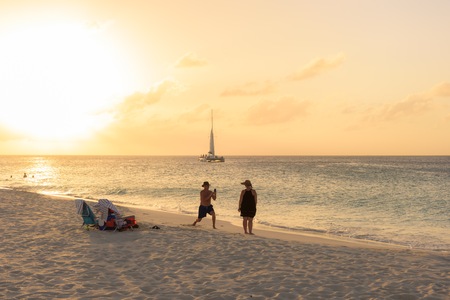 Oranjestad, Aruba - January 7, 2018: People relax and have fun in the famous Eagle Beach in Aruba at sunset.のeditorial素材