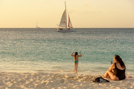 Oranjestad, Aruba - January 7, 2018: People relax and have fun in the famous Eagle Beach in Aruba at sunset.のeditorial素材
