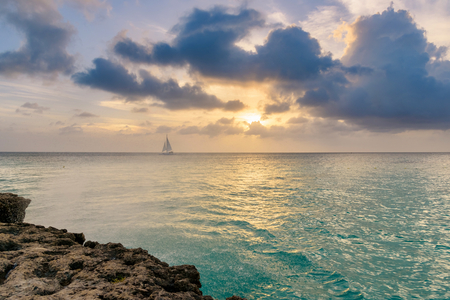 Tropical seascape with a boat at the horizon at sunset.の写真素材