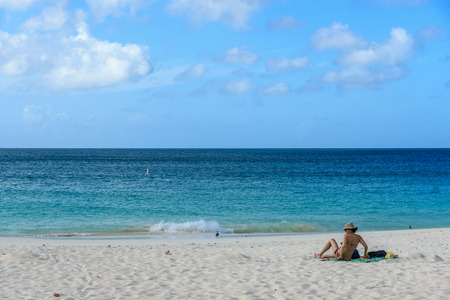 Oranjestad, Aruba - January 13, 2018: A woman relax in the white sand of the idyllic Eagle Beach in Aruba.の写真素材