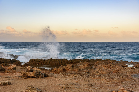 The force of the sea in Aruba with waves break on the rocks, near the Natural Bridge.の写真素材