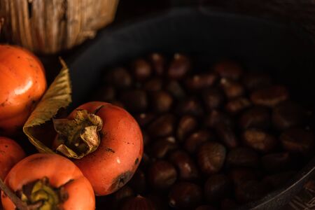 Flat lay composition with chestnust, pomegranate and pumpkins on a wooden tableの写真素材