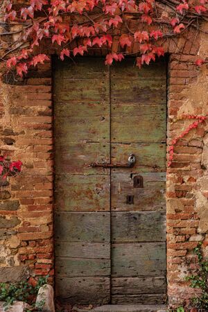 An abandoned building surrounded by red ivy. Autumn season.の写真素材