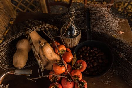 Flat lay composition with chestnust, pomegranate and pumpkins on a wooden tableの写真素材