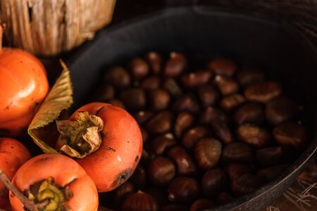 Flat lay composition with chestnust, pomegranate and pumpkins on a wooden tableの写真素材