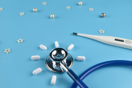 Stethoscope and thermometer on blue background.の写真素材