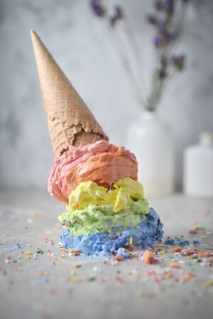 Melting rainbow ice cream scoops and waffle cone. Close up.の写真素材