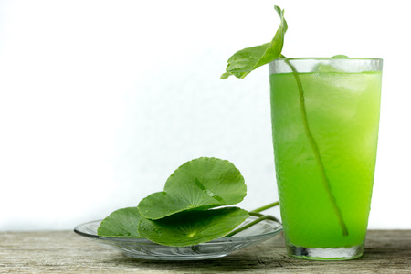 Heart shape of green Asiatic Pennywort (Centella asiatica ,Water pennywort ) on the table,healthy food against woodの写真素材