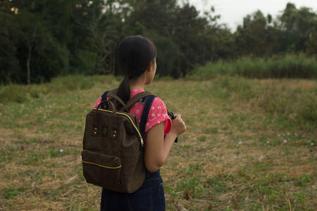 travel, hiking, backpacking, tourism and people concept - happy with backpacks walking along farm.の写真素材